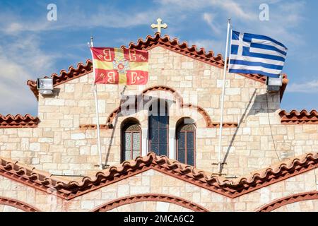 Le bandiere bizantine e greche sventolano davanti alla Santa Chiesa dei Santi Apostoli Pietro e Paolo nel comune di Hymettos, Atene, Grecia Foto Stock