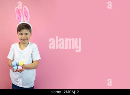 Ampia Pasqua banner.Un ragazzo nelle orecchie di una lepre tiene le uova nelle sue mani. Foto Stock