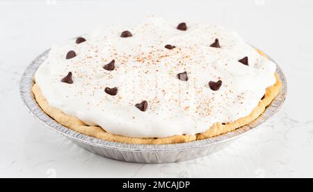 Una torta alla crema di cioccolato sormontata con gocce di cioccolato e cacao sulla panna montata Foto Stock