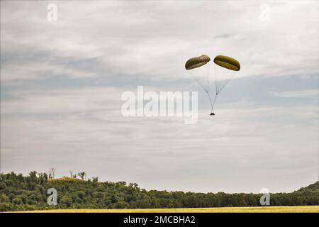 Un pacchetto airdrop paracadute giù dopo essere stato rilasciato da un C-130 Hercules il 28 giugno 2022, sopra un'area di addestramento a Fort McCoy, Wisconsin. Gli aerei con unità dell'Ala 934th Airlift di Minneapolis-Saint Paul Air Reserve Station, Minnn., hanno completato l'addestramento airdrop per diversi giorni alla fine di giugno a Fort McCoy. Fort McCoy è uno spazio di allenamento regolare per l'airdrop Practice da parte delle forze di mobilità dell'aeronautica ogni anno. Inoltre, le tradizionali gocce d'aria degli aerei dell'aeronautica militare, come il C-130 Hercules e il C-17 Globemaster III, sono ad altitudini di dovunque fra 400 e 1.000 piedi e Fort McCoy offre l'abbondanza o Foto Stock