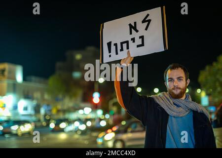 Haifa, Israele - 21 gennaio 2023: La gente protesta con segni contro i piani legislativi del nuovo governo. Un uomo tiene un poster con la scritta Foto Stock