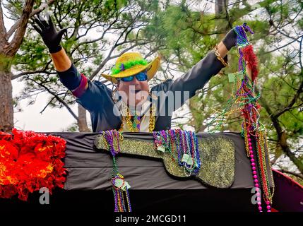 Un uomo lancia branelli di Mardi Gras durante la sfilata di Krewe de la Dauphine Mardi Gras, 21 gennaio 2023, a Dauphin Island, Alabama. Foto Stock