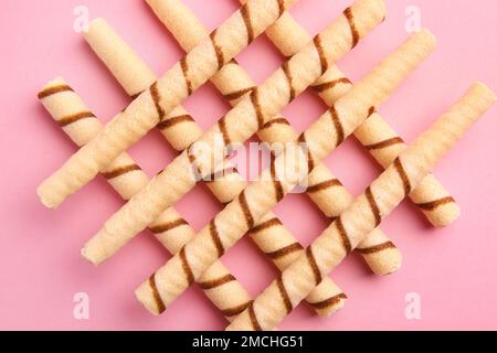 Gustosi wafer roll su sfondo rosa Foto Stock