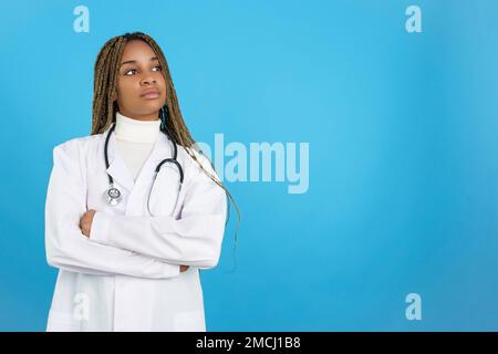 Seria dottoressa africana in uniforme con le braccia piegate Foto Stock