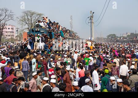 Dhaka, Bangladesh. 22nd Jan, 2023. I devoti musulmani viaggiano su treni rischiosi sovraffollati dopo aver assistito all'Akheri Munajat o alle preghiere finali, al Biswa Ijtema di Tongi, Dhaka, Bangladesh. Gli abitanti del luogo affrontano il viaggio salendo, aggrappandosi e clambering lungo i tetti delle locomotive. Senza posti a sedere all'interno, molti pendolari decidono di correre il rischio e di scegliere una vista sul tetto per il loro viaggio fuori dalla città di Dhaka. Credit: Joy Saha/Alamy Live News Foto Stock