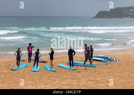 Lezioni di surf Impara a fare surf a Manly Beach Sydney, istruttore di surf insegna a un gruppo di principianti come fare surf, Sydney, NSW, Australia Foto Stock