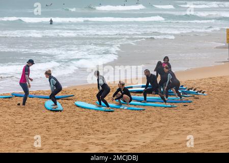 Lezioni di surf Impara a fare surf a Manly Beach Sydney, istruttore di surf insegna a un gruppo di principianti come fare surf, Sydney, NSW, Australia Foto Stock
