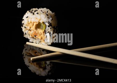 sushi su una superficie nera riflettente Foto Stock