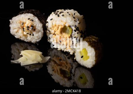 sushi su una superficie nera riflettente Foto Stock