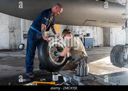 Senior Airman Owen Schott, a sinistra, e Airman 1st Class Trevor Finley, a destra, 44th manutenzione unità aeromobili, applicare il lubrificante a una ruota di atterraggio principale su Kadena Air base, Giappone, 6 luglio 2022. La lubrificazione della ruota evita la corrosione, garantendo la capacità di Kadena di mantenere un Indo-Pacific libero e aperto. Foto Stock