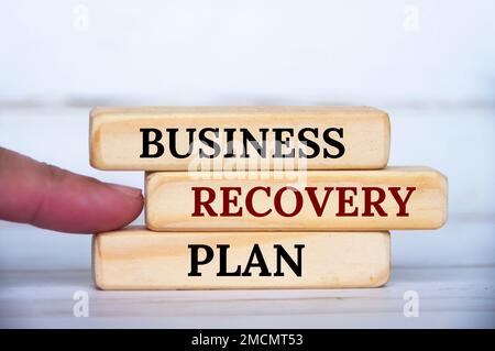Un dito indica il testo del piano di ripristino aziendale su blocchi di legno. Concetto di recupero aziendale. Foto Stock