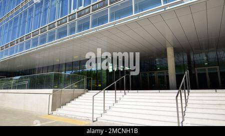 Frammento astratto di architettura contemporanea, pareti in vetro e cemento. Edificio degli uffici. Foto Stock