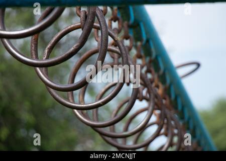 Vecchi anelli arrugginiti su una catena su una barra orizzontale per la ginnastica sulla strada, campo sportivo in Ucraina Foto Stock