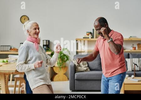 Coppia anziana multietnica che si diverte durante una lezione di ballo in camera Foto Stock