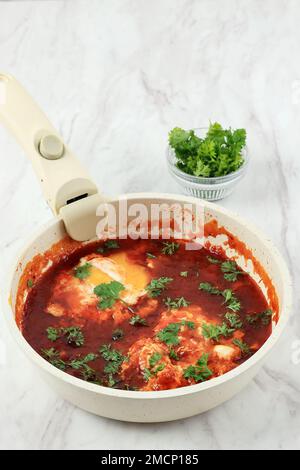 Shakshuka in una padella. Le uova in camicia in pomodoro piccante salsa di pepe. Foto Stock