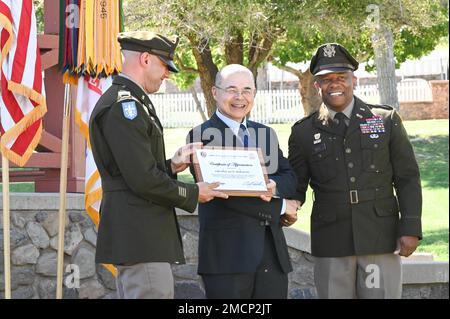 5 Joe Okabayashi, oratore ospite durante la celebrazione del compleanno del 104th° ufficiale della garanzia presso lo storico Brown Parade Field a Fort Huachuca, Ariz. Luglio 8, è stato presentato con una targa da (sinistra) Chief Warrant Officer 5 Pete Davis, Chief Training Branch Chief e (destra) Chief Warrant Officer 5 Deshawn Bell, Network Enterprise Technology Command Chief Warrant Officer. Foto Stock