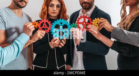 Lavoro di squadra di imprenditori lavorano insieme e combinano le parti di ingranaggi come partnership e integrazione Foto Stock