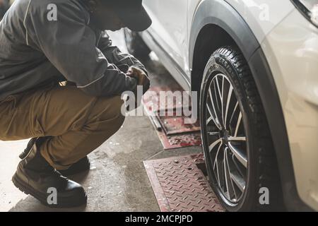 Controllo meccanico della geometria e della sospensione di una ruota di un'auto con attrezzi di precisione. Foto di alta qualità Foto Stock