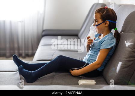 Ragazza carina con maschera nebulizzatore. Foto Stock