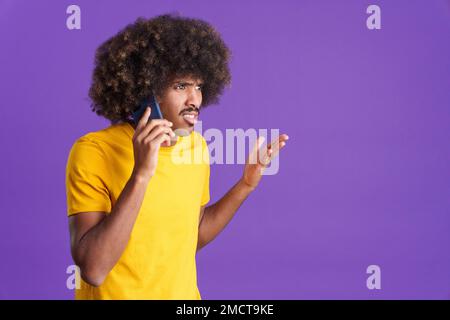 Un africano arrabbiato che parla con il cellulare Foto Stock