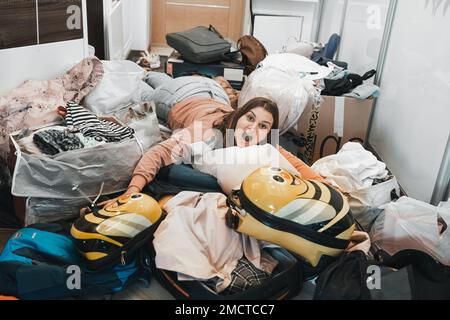 Difficile preparazione al viaggio in famiglia. Spostamento, imballaggio disimballaggio di molte cose, vestiti, valigie, bagaglio a casa in appartamento. Molti pacchetti, bags.M Foto Stock