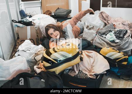 Difficile preparazione al viaggio in famiglia. Spostamento, imballaggio disimballaggio di molte cose, vestiti, valigie, bagaglio a casa in appartamento. Molti pacchetti, bags.M Foto Stock