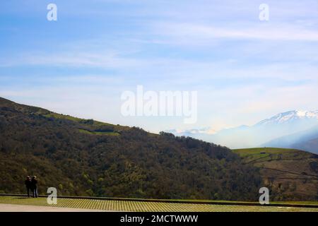 Vasto paesaggio con cime di montagna e due persone isolate che si ammirano La vista vicino al Cueva el Soplao Picos de Europa Cantabria Spagna aprile 2010 Foto Stock