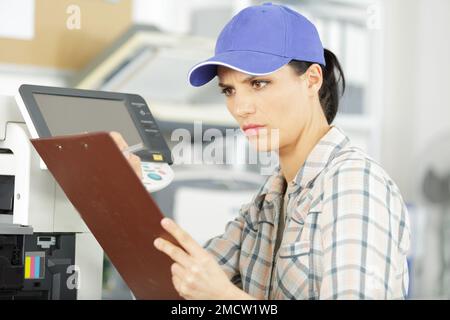 la lavoratrice sta leggendo un clipboard Foto Stock