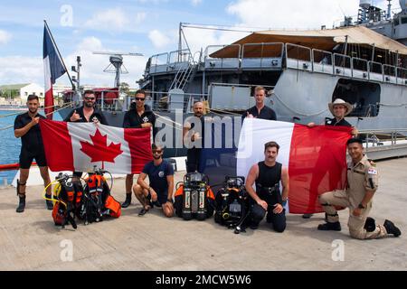 20220710-o-QR492-1001-CA PEARL HARBOR (10 luglio 2022) Divers from Royal Canadian Navy fregate HMCS Vancouver (FFH 331) and French Navy fregate FS Prairial (F731) posano per una foto di gruppo mentre accanto alla Joint base Pearl Harbor-Hickam durante Rim of the Pacific (RIMPAC) 2022, 10 luglio. Ventisei nazioni, 38 navi, quattro sottomarini, più di 170 aerei e 25.000 personale partecipano al RIMPAC dal 29 giugno al 4 agosto nelle isole hawaiane e nella California meridionale. Il più grande esercizio marittimo internazionale del mondo, RIMPAC offre un’opportunità di formazione unica promuovendo al contempo un Foto Stock