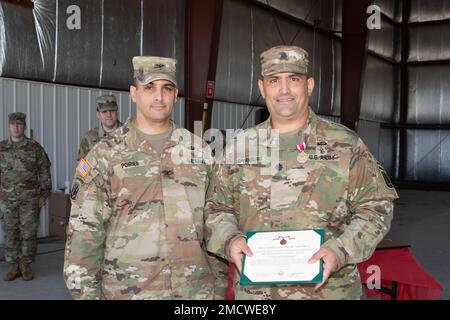 STATI UNITI Il Lt. Dell'esercito col Nathan Speanburg, comandante uscente, 572nd Battaglione dell'ingegnere della Brigata, 86th squadra di combattimento della Brigata della Fanteria (montagna), la Guardia Nazionale dell'esercito del Vermont, riceve una Medaglia di Servizio Meritorious dell'esercito durante una cerimonia di cambio di comando tenuta all'aeroporto regionale del Vermont meridionale di Rutland, North Clarendon, Vt., 10 luglio 2022. STATI UNITI Leonard Poirier, comandante, 86th squadra di combattimento della Brigata di Fanteria (montagna), Guardia Nazionale dell'Esercito del Vermont, presenta la medaglia. Foto Stock