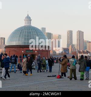 Entrata a forma di cupola al Greenwich Foot Tunnel con un busker all'esterno mentre la gente cammina per un giorno d'inverno, Londra Inghilterra Foto Stock