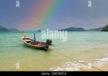 Barca su una spiaggia solitaria a Phuket, Rainbow, Thailandia Foto Stock
