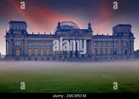 Reichstag a Berlino all'alba e nebbia al suolo contro la luce. Berlino, Germania Foto Stock