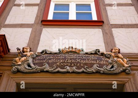 Cartouche barocca con putto sopra la vecchia porta di legno, scultura sul fuoco della città del 1752, casa a graticcio Old Town Wernigerode, Harz, Sassonia-Anhalt Foto Stock