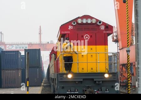 (230122) -- CHONGQING, 22 gennaio 2023 (Xinhua) -- Un treno merci intermodale ferroviario-marittimo che trasporta contenitori di merci, compresi automobili, motocicli, motori e carbonato di sodio, Aspettate la partenza alla Stazione Centrale di Tuanjie Village, nella zona sud-occidentale di Chongqing, il 22 gennaio 2023. È stato il primo treno merci in uscita della città del nuovo corridoio internazionale di commercio terra-mare nell'anno del coniglio. Le merci sul treno saranno trasportate al porto di Qinzhou sulla costa meridionale del paese, da dove saranno spedite in Indonesia, nelle Filippine, in Australia e in altri paesi e regioni. (X Foto Stock
