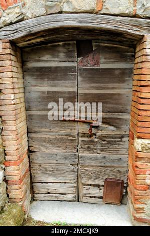 Porta rustica in legno con grande bullone arrugginito, Roccatederighi Mountain Village Toscana, Italia, Foto Stock