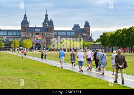 Amsterdam, Paesi Bassi - 2022 agosto: Persone che camminano attraverso un parco verso il famoso Museo Rijks nel centro della città Foto Stock