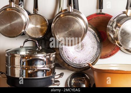 Pentole e padelle sono appese in cucina. Utensili da cucina, interni domestici. Foto Stock
