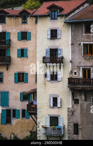 Vista ravvicinata degli edifici storici e colorati lungo la scogliera di Pont-en-Royans, Francia Foto Stock