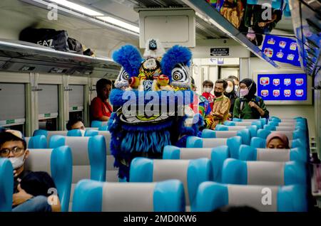 (230122) -- WEST JAVA, 22 gennaio 2023 (Xinhua) -- i passeggeri guardano uno spettacolo di danza leone a bordo di un treno durante una celebrazione del Capodanno cinese a Bandung, West Java, Indonesia, 22 gennaio 2023. (Foto di Septianjar Muharam/Xinhua) Foto Stock