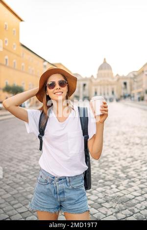 Felice giovane donna turistico bevande take away caffè a Roma, Italia. Giovane donna, in un cappello estivo, con delizioso gelato. Spazio per il testo Foto Stock