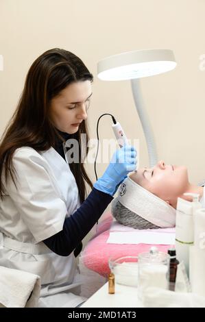 Ivano-Frankivsk, Ucraina 20 dicembre 2022: Un estetista esegue una procedura di mesoterapia ringiovanente utilizzando dermapen. Foto Stock