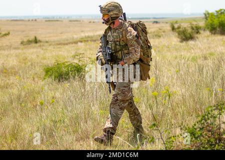 BABADAG TRAINING AREA, Romania-- un Airman con il Regno Unito 140th Expeditionary Air Wing si sposta verso la zona di pick-up durante la formazione di recupero del personale con 3-227 AHB, 12 luglio 2022. La formazione regolare sull'interoperabilità con i partner e gli alleati della NATO costruisce fiducia e disponibilità, aumentando la capacità di deterrenza e difesa. Foto Stock