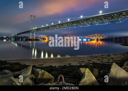 Il Forth Road Bridge e il Forth Railway Bridge di notte che attraversano Firth of Forth, Queensferry, vicino a Edimburgo, Scozia, Regno Unito Foto Stock