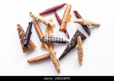 Pastille di frutta isolato su uno sfondo bianco. Roll-up di frutta a base di lampone, mele, arancia e ribes. Foto Stock