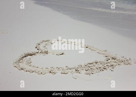 Cuore disegnato nella sabbia. Sfondo spiaggia. Segno di amore che scrive sulla sabbia. Il concetto di turismo di San Valentino o sfondo Foto Stock