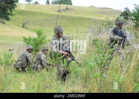 I cadetti dell'ufficiale dell'esercito britannico con la Royal Military Academy Sandhurst sono valutati sulle loro abilità di direzione durante un assalto simulato alla Grafenwoehr Training Area, Grafenwoehr, Germania, 12 luglio 2022. La simulazione faceva parte della Exercise Dynamic Victory, una delle tante sfide di formazione che si trovano tra un ufficiale Cadet e la loro messa in servizio come ufficiale dell'esercito della Royal Military Academy Sandhurst. Foto Stock