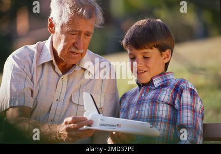 Nonno con suo nipote all'aperto, in possesso di un modello della navetta di volo originale NASA Foto Stock