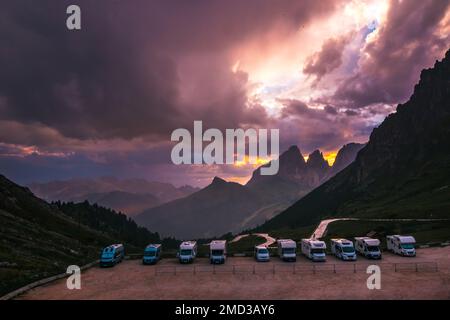 Camper e camper parcheggiati in un parcheggio caravan nelle Alpi italiane su un passo di montagna con un bellissimo tramonto. Viaggiare con un RV. Migliore Foto Stock