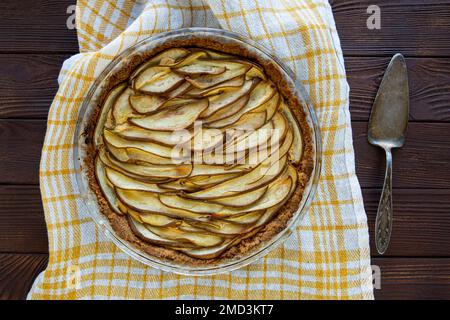 Torta di frutta gustosa su asciugamano da cucina su tavolo rustico in legno, vista dall'alto. Stile vintage. Foto Stock